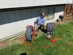 Inland Trenchless crew member performs sewer line video inspection for homeowner.
